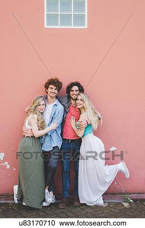 Couples hugging against pink wall background View Large Photo Image Stock Image - Couples hugging against pink wall background. Fotosearch