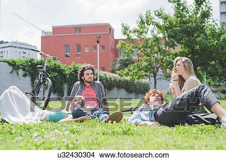 Picture - Couples relaxing in park. Fotosearch