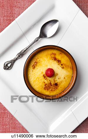 Stock Photograph - Creme brulee in bowl on white plate. Fotosearch