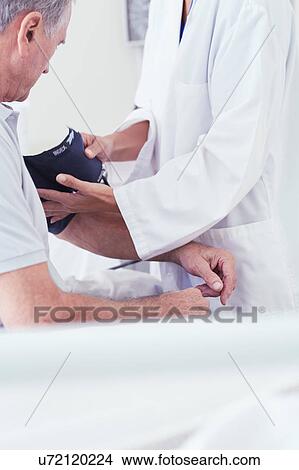 Cropped shot of female doctor using blood pressure gauge on senior male patient on hospital bed View Large Photo Image Picture - Cropped shot of female doctor using blood pressure gauge on senior male patient on hospital bed. Fotosearch