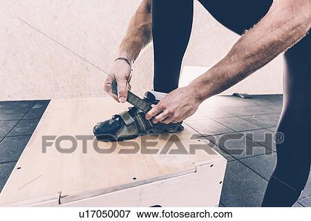 Cropped shot of man fastening trainers in cross training gym View Large Photo Image Stock Photo - Cropped shot of man fastening trainers in cross training gym. Fotosearch