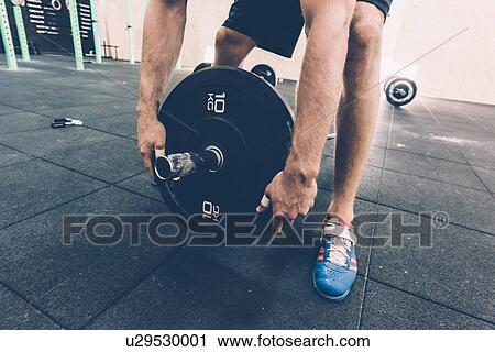 Cropped shot of man preparing barbell in cross training gym View Large Photo Image Stock Image - Cropped shot of man preparing barbell in cross training gym. Fotosearch