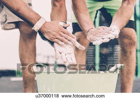 Cropped shot of two male cross trainers chalking hands in gym View Large Photo Image Stock Photo - Cropped shot of two male cross trainers chalking hands in gym. Fotosearch