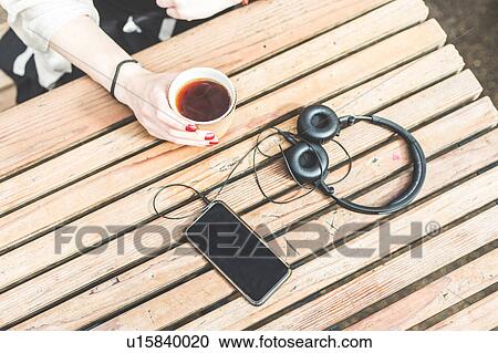 Stock Image - Cropped view of woman's hand holding disposable cup, London, UK. Fotosearch
