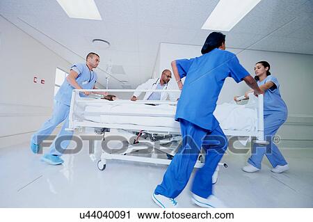 Stock Image - Doctor and medical running with patient bed in hospital emergency. Fotosearch
