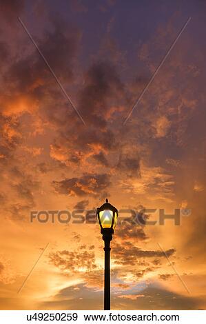 Stock Photo - Dramatic sunset sky with lamp post in foreground. Fotosearch