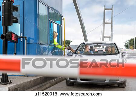 Stock Photo - Driver in car paying toll booth at bridge. Fotosearch