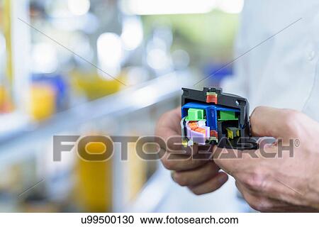 Stock Image - Engineer holding 3D printed parts in factory, close up. Fotosearch