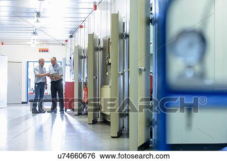 Stock Photograph - Engineers with laptop in testing facility in factory. Fotosearch
