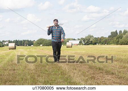 Farmer in field carrying spade on shoulder View Large Photo Image Stock Photography - Farmer in field carrying spade on shoulder. Fotosearch