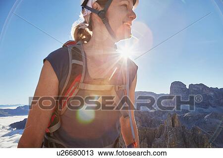 Stock Image - Female hiker hiking in sunlit Dolomites, Sexten, South Tyrol, Italy. Fotosearch