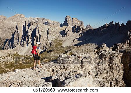 Stock Photo - Female hiker hiking up Dolomites, Sexten, South Tyrol, Italy. Fotosearch