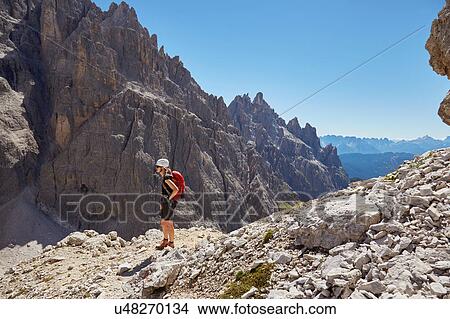 Female hiker looking out at Dolomites, Sexten, South Tyrol, Italy View Large Photo Image Picture - Female hiker looking out at Dolomites, Sexten, South Tyrol, Italy. Fotosearch