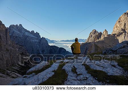 Female hiker looking out at Dolomites above clouds, Sexten, South Tyrol, Italy View Large Photo Image Stock Image - Female hiker looking out at Dolomites above clouds, Sexten, South Tyrol, Italy. Fotosearch