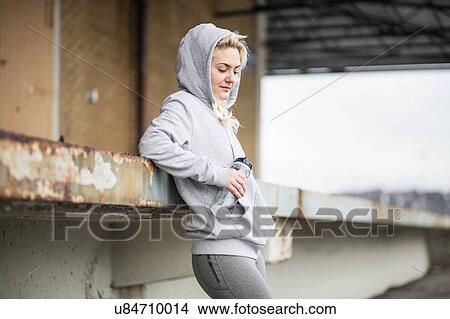 Female runner leaning against warehouse platform View Large Photo Image Picture - Female runner leaning against warehouse platform. Fotosearch