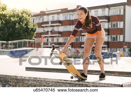 Stock Photography - Female skateboarder preparing on skateboard ramp. Fotosearch