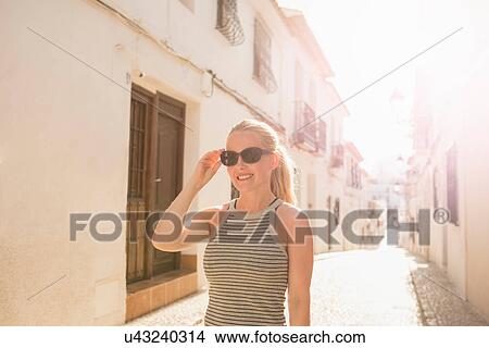 Female tourist strolling along sunlit alley, Altea, Alicante Province, Spain View Large Photo Image Picture - Female tourist strolling along sunlit alley, Altea, Alicante Province, Spain. Fotosearch