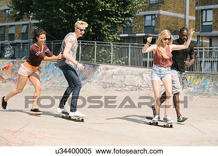 Stock Photography - For adult friends learning to skateboard in skatepark. Fotosearch