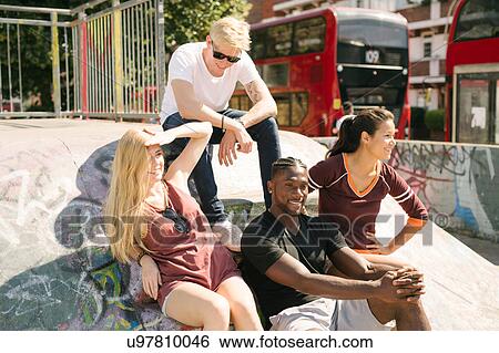 Four male and female friends sitting chatting in city skatepark View Large Photo Image Stock Photograph - Four male and female friends sitting chatting in city skatepark. Fotosearch