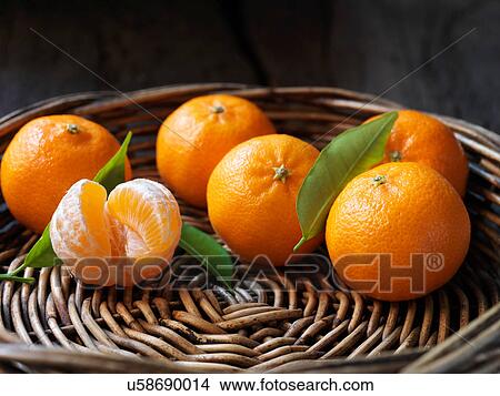 Fresh organic fruit, clementines with leaves in wicker bowl View Large Photo Image Picture - Fresh organic fruit, clementines with leaves in wicker bowl. Fotosearch