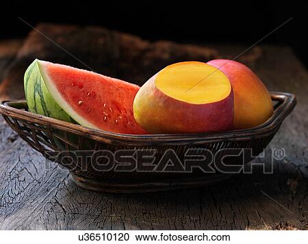 Stock Image - Fresh organic fruit, mango and water melon. Fotosearch