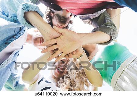 Friends doing team huddle in park View Large Photo Image Stock Image - Friends doing team huddle in park. Fotosearch