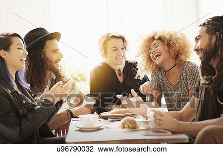 Friends having coffee together in cafe View Large Photo Image Stock Image - Friends having coffee together in cafe. Fotosearch