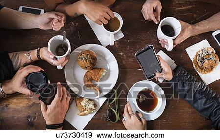 Stock Photo - Friends having coffee together in cafe. Fotosearch