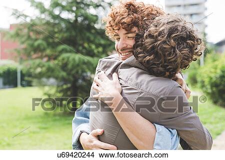 Picture - Friends hugging in park. Fotosearch