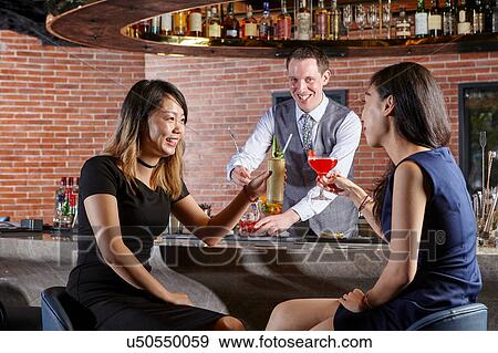 Stock Photo - Friends in bar making a toast. Fotosearch
