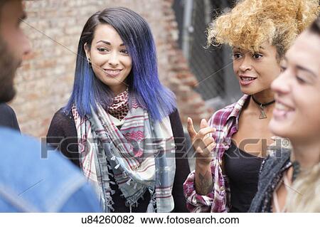 Stock Image - Friends laughing and talking outdoors. Fotosearch