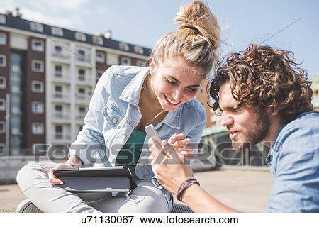 Stock Photo - Friends on social media outdoors. Fotosearch