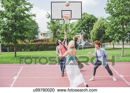 Stock Image - Friends playing basketball. Fotosearch
