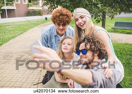 Friends taking selfie in park View Large Photo Image Picture - Friends taking selfie in park. Fotosearch