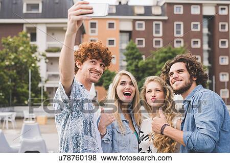Stock Photo - Friends taking selfie outdoors. Fotosearch