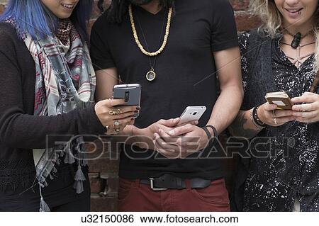 Stock Photograph - Friends using smartphones. Fotosearch