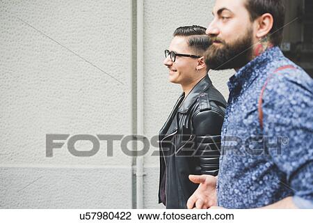 Friends walking past grey wall View Large Photo Image Stock Image - Friends walking past grey wall. Fotosearch