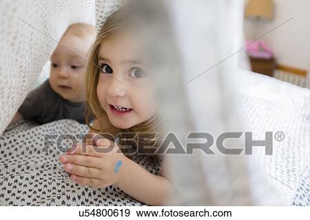 Girl (2-3) and baby brother (6-11 months) hiding under bed covers View Large Photo Image Stock Photo - Girl (2-3) and baby brother (6-11 months) hiding under bed covers. Fotosearch