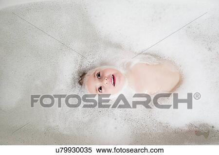 Stock Photography - Girl (2-3) lying in bathtub. Fotosearch