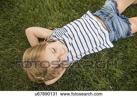 Stock Image - Girl (2-3) lying on grass. Fotosearch