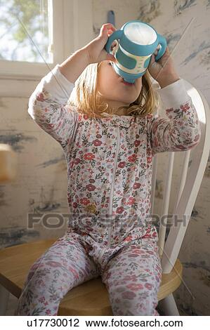 Girl (2-3) sitting on chair and drinking milk from sippy cup View Large Photo Image Stock Image - Girl (2-3) sitting on chair and drinking milk from sippy cup. Fotosearch