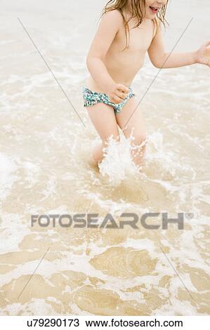Girl (2-3) wading in ocean and splashing View Large Photo Image Stock Image - Girl (2-3) wading in ocean and splashing. Fotosearch