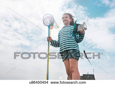 Girl holding fishing nets looking away smiling View Large Photo Image Picture - Girl holding fishing nets looking away smiling. Fotosearch
