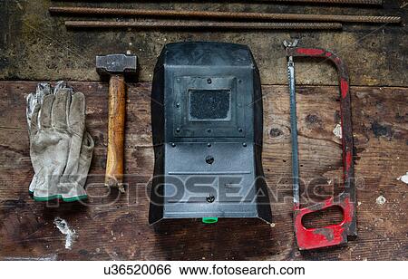 Stock Photograph - Gloves, hammer, welding visor, saw. Fotosearch