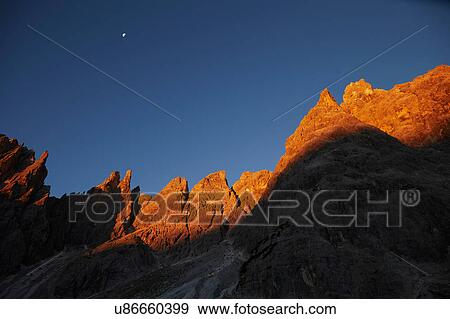 Stock Photo - Golden rock face at sunset in the Dolomites, Sexten, South Tyrol, Italy. Fotosearch