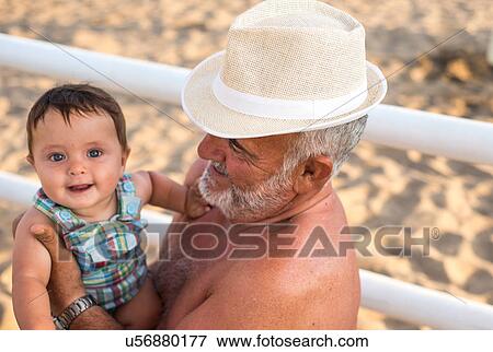 Grandfather holding smiling baby boy View Large Photo Image Stock Photo - Grandfather holding smiling baby boy. Fotosearch