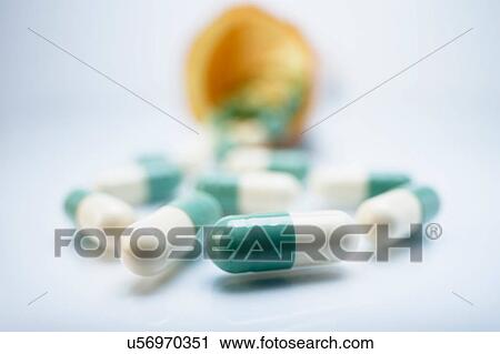 Stock Image - Green and white colour capsule pills. Fotosearch