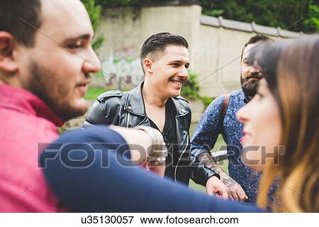 Group of friends chatting by roadside View Large Photo Image Stock Photo - Group of friends chatting by roadside. Fotosearch