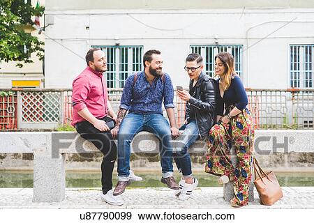 Group of friends chatting by roadside View Large Photo Image Stock Photo - Group of friends chatting by roadside. Fotosearch