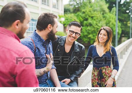Stock Photograph - Group of friends chatting by roadside. Fotosearch